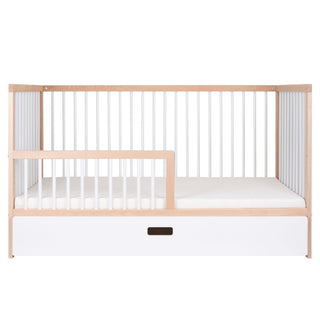 Crib with wooden frame and white mattress on a white background